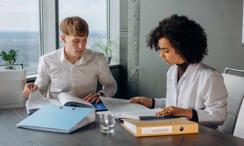 Besprechung mit zwei Personen im Büro mit Unterlagen