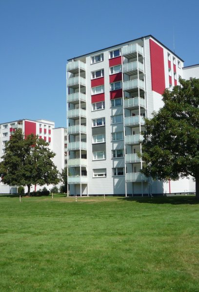 Fassade Mehrfamilienhaus mit Grünflächen