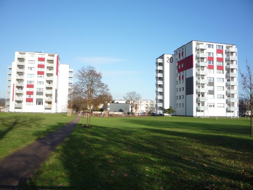 Fassade Mehrfamilienhaus mit Grünflächen