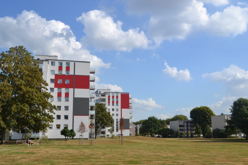 Fassade Mehrfamilienhaus mit Grünflächen