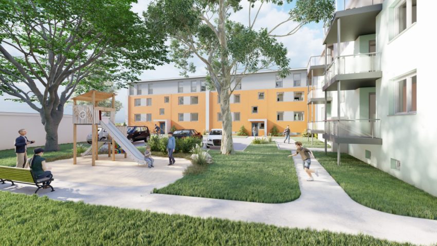 Fassade Mehrfamilienhaus mit Grünflächen und Spielplatz