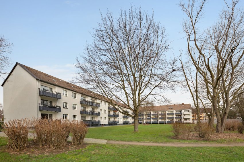 Fassade Mehrfamilienhaus mit Grünflächen