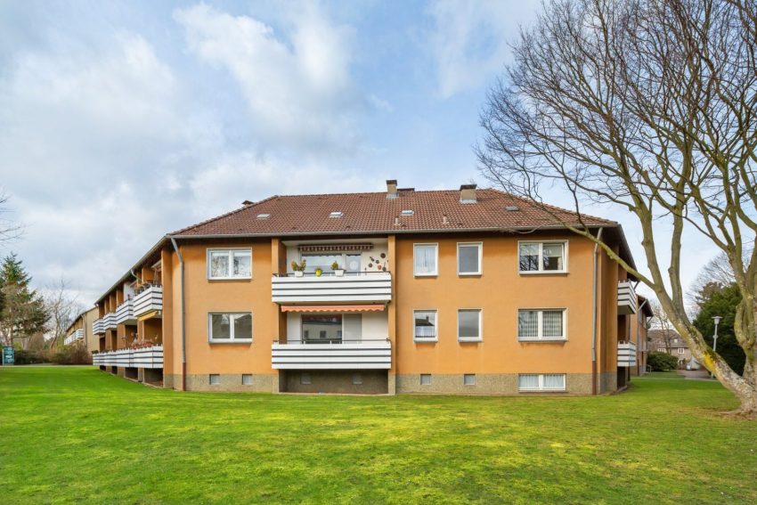 Fassade Mehrfamilienhaus mit Grünflächen