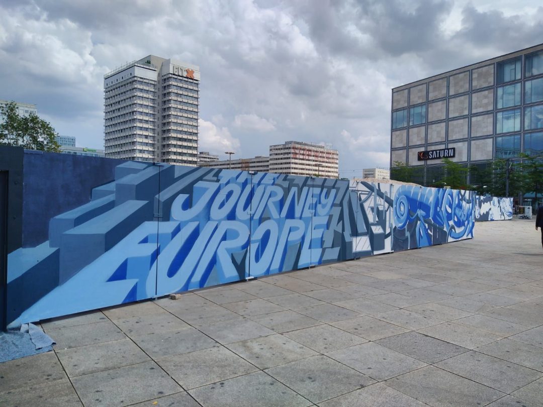Wandgemälde auf Mauer vor Hochhaus