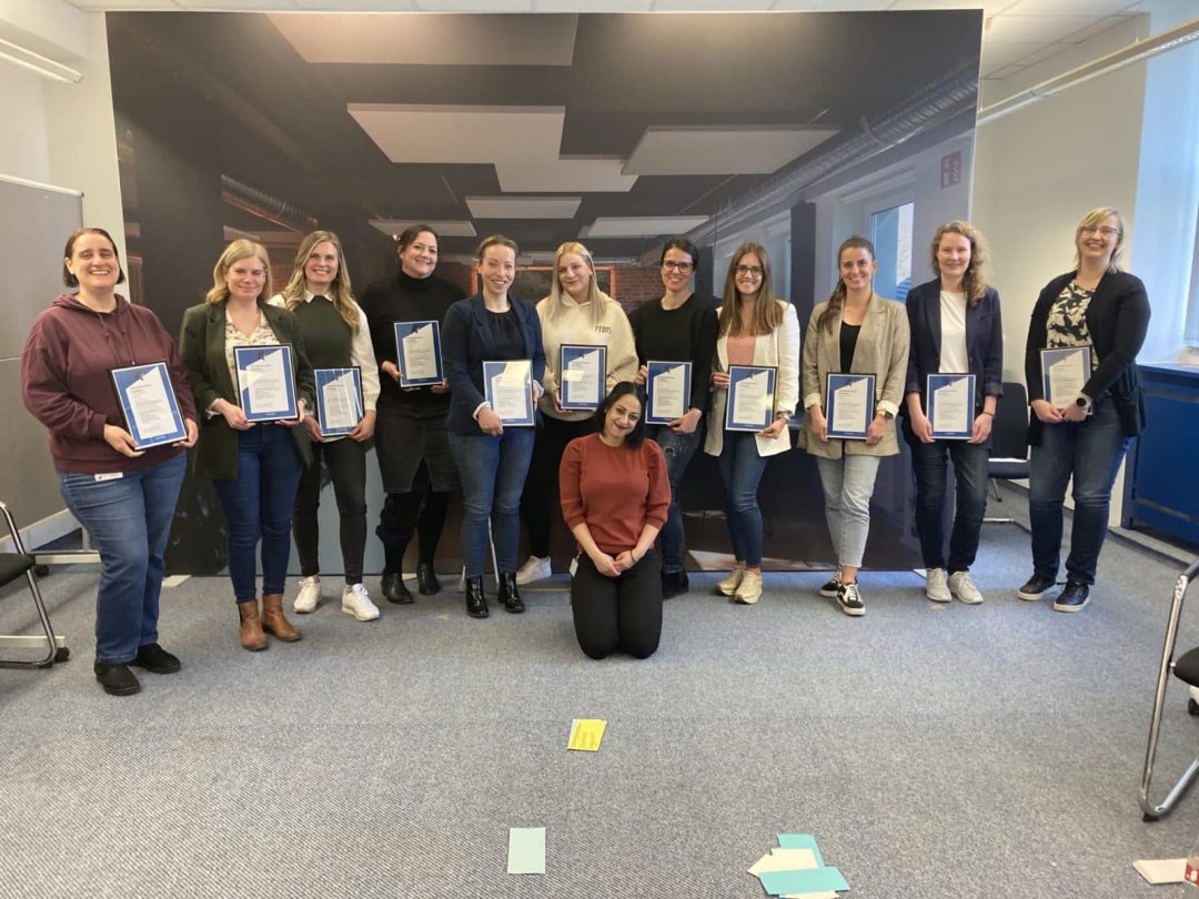 Elf Frauen mit Urkunde in der Hand