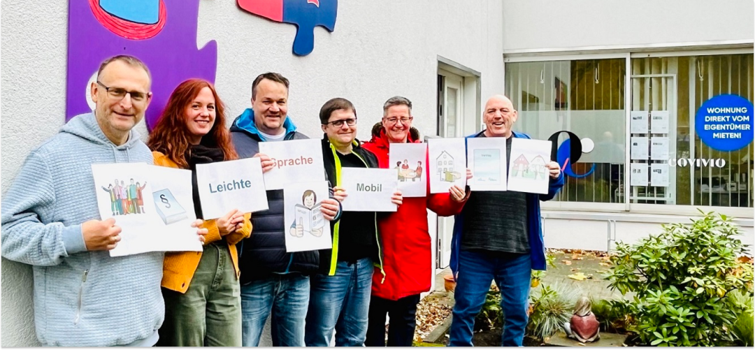 sechs Personen halten Schilder mit Grafiken und Wörtern