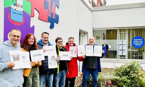 sechs Personen halten Schilder mit Grafiken und Wörtern