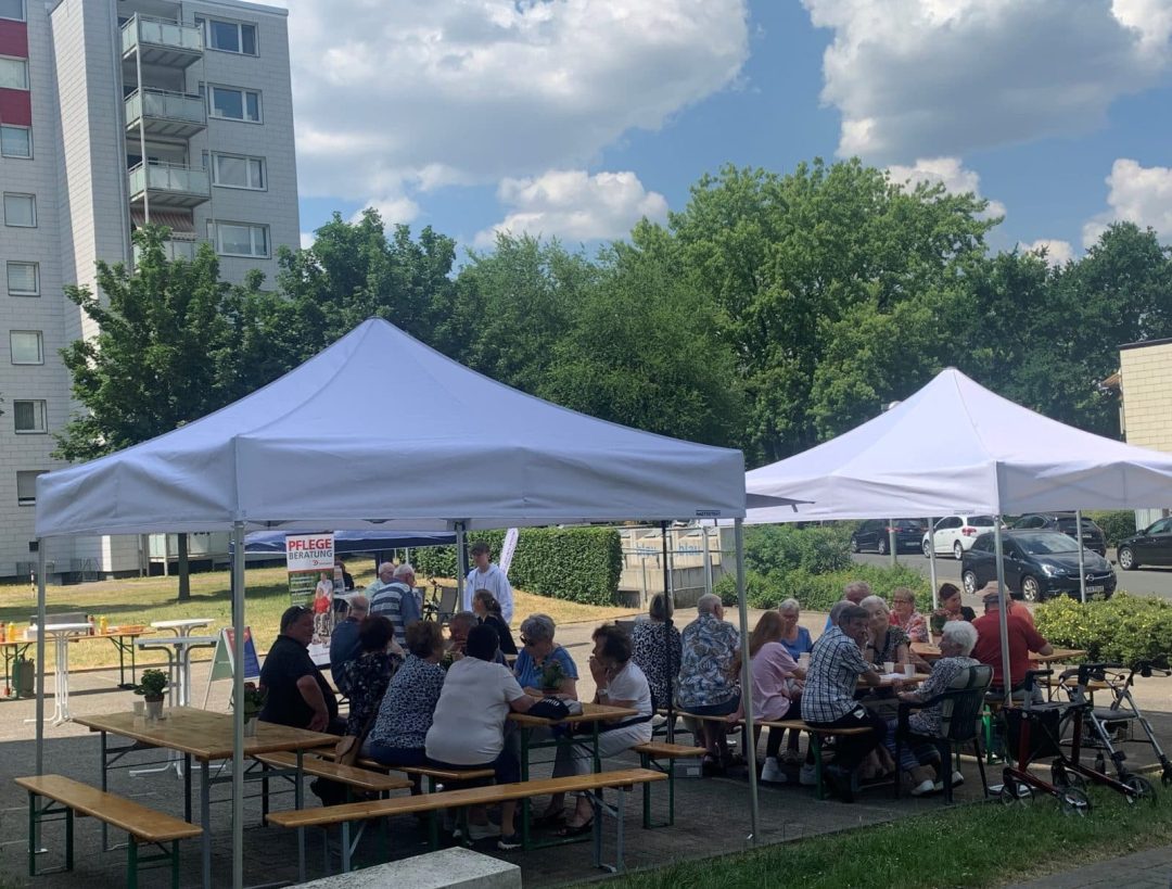 Personen sitzen an Bierzelttischen