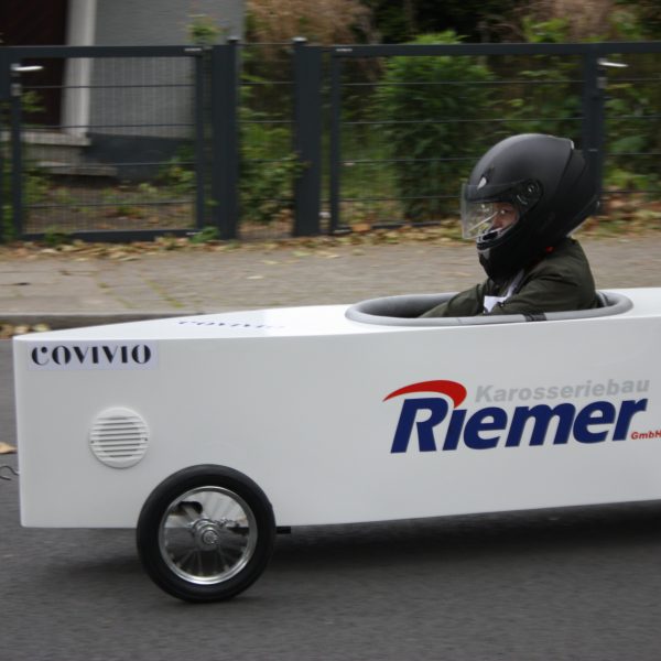 Person mit Helm in Seifenkiste