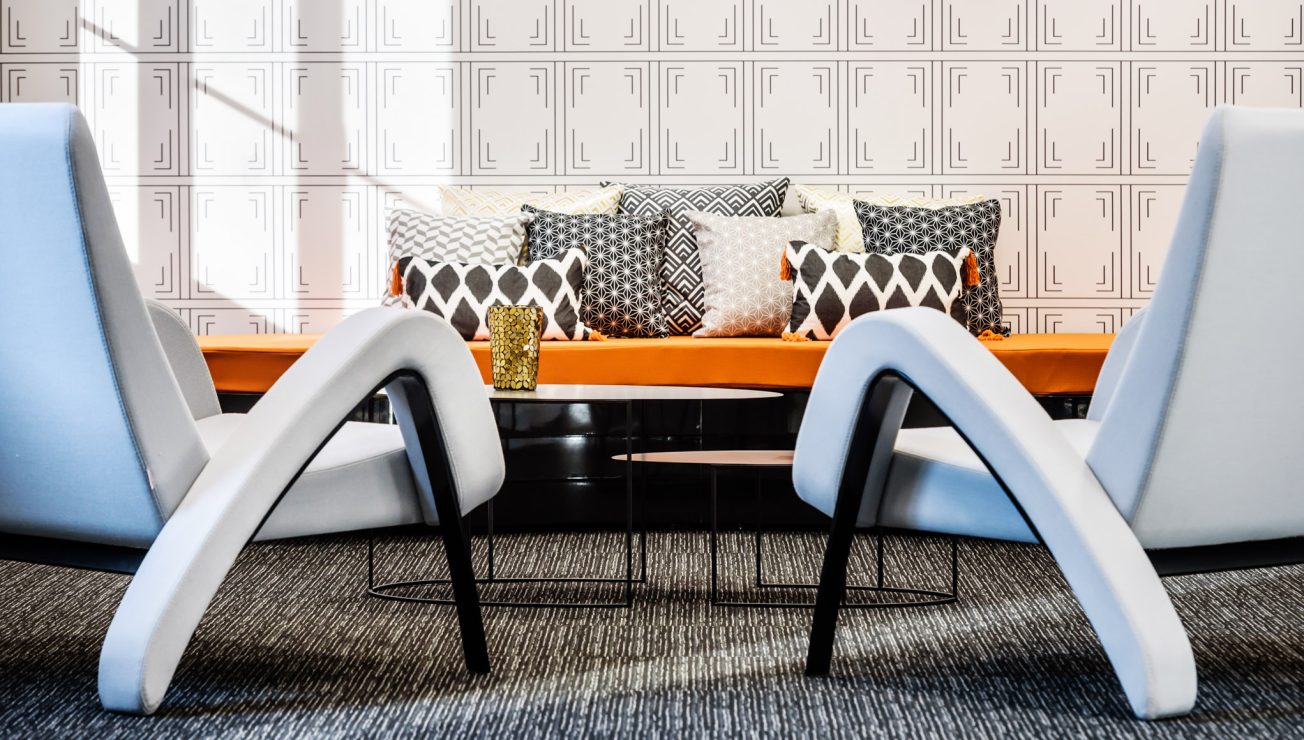 Eine Sitzbank mit zwei Beistelltischen und Sesseln sowie Dekoration