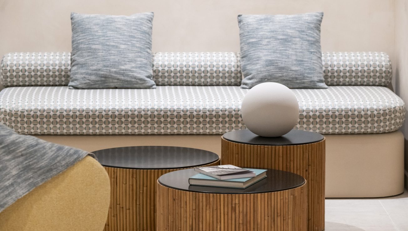 Eine Sitzbank mit drei Beistelltischen und Dekoration