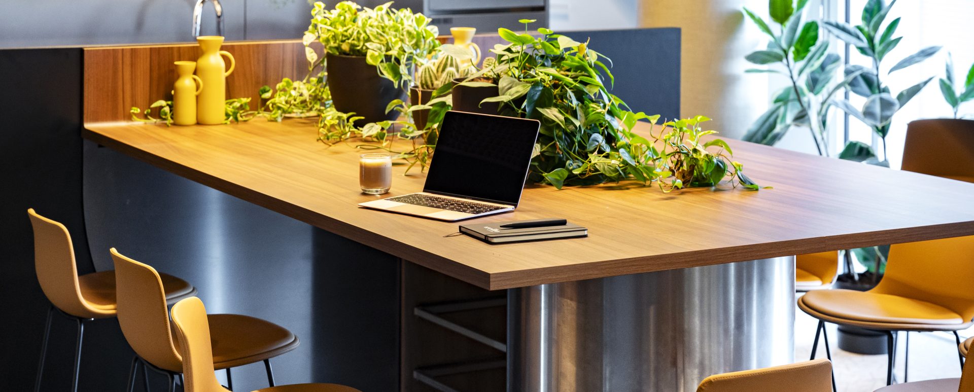 Ein Bartisch mit Stühlen und Küche im Hintergrund