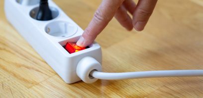 Jemand schaltet eine Steckdosenverlängerung an