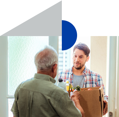 Zwei Männer an einer Tür, einer hält einen Karton mit Lebensmitteln