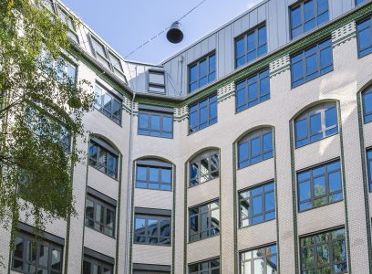 Mehrstöckiges Gebäude mit weißen Fassaden, vielen Fenstern.