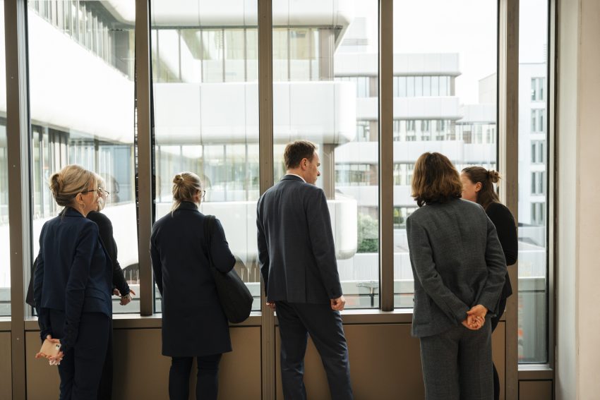 Alle Gäste stehen am Fenster mit Blick auf das ICON by Covivio