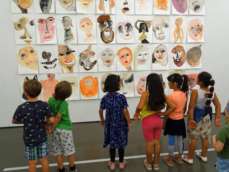 Kinder vor selbst gemalten Bildern