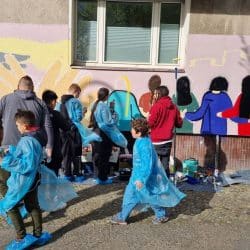 Kinder malen Kunstwerk auf Hauswand