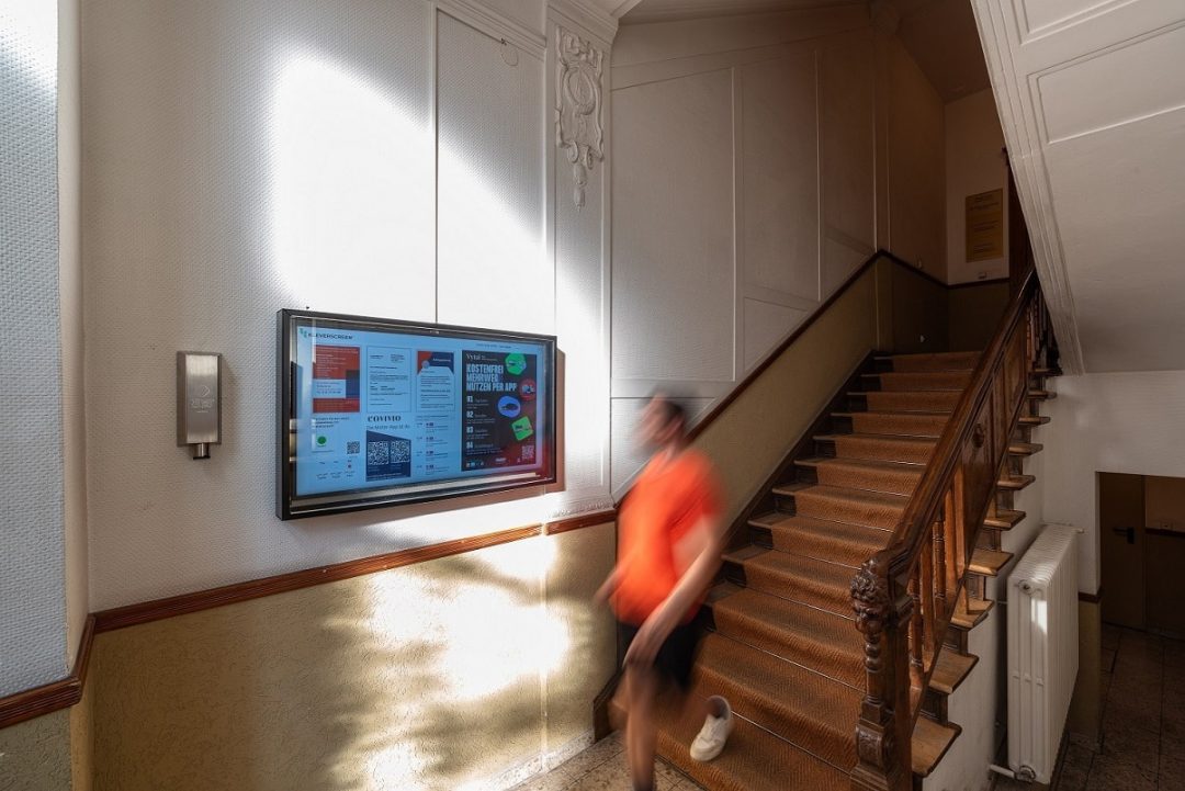 Bildschirm mit Informationen in Treppenhaus