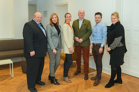 Gruppe von sechs Personen, teils im Anzug