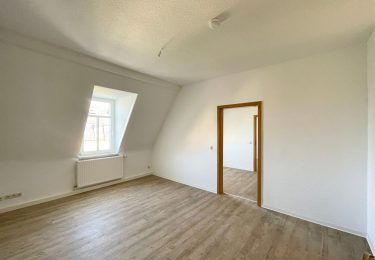 Wohnzimmer mit Durchgang zu Küche und Schlafzimmer