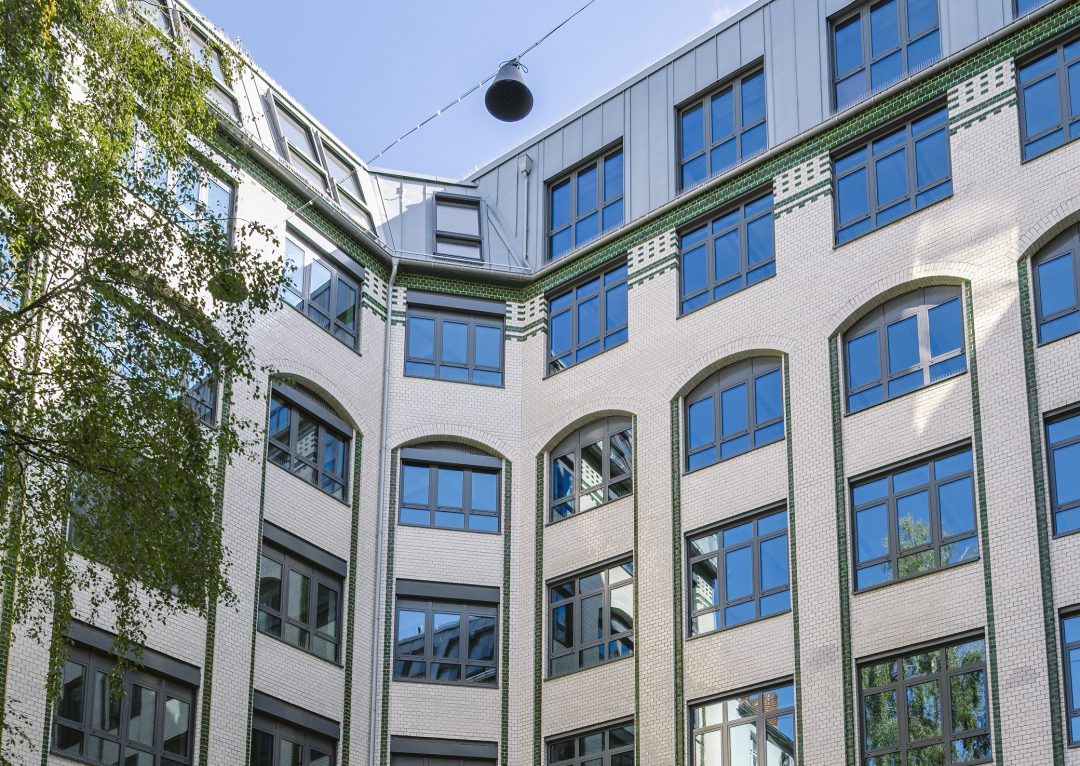 Mehrstöckiges Gebäude mit weißen Fassaden, vielen Fenstern.