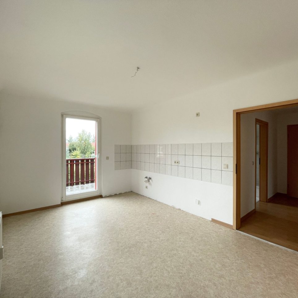 Küche mit Fliesenspiegel und Zugang zu Balkon